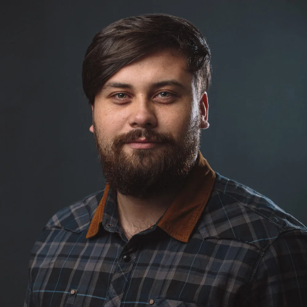 Portrait of a man with a beard and plaid shirt, representing NovaOne Property Services' professional team, emphasizing reliability and customer satisfaction in cleaning services.