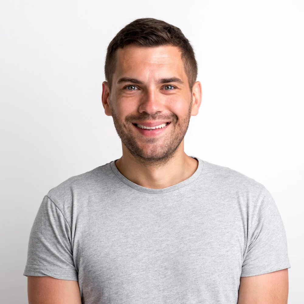Smiling man in a gray t-shirt, representing NovaOne Property Services' friendly and professional lawn care team.